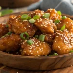 Spicy Honey Chicken glazed with sticky honey sauce, garnished with sesame seeds and green onions